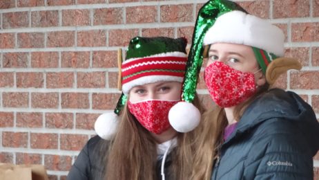 2 girls with santa green Santa hats & red masks at Breakfast with Santa, Cambridge