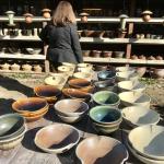 Pottery on a table in foreground with lady in the background