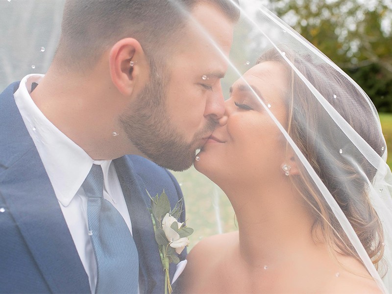 couple kissing under veil A Rustic Wedding at Sugar Island Barn in Watertown